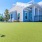 a large white house with a blue fence and a lawn in front