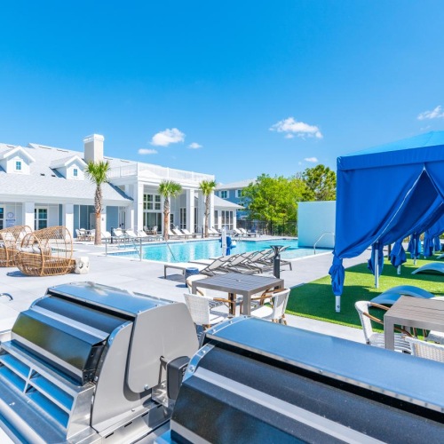 a pool with tables and chairs outside